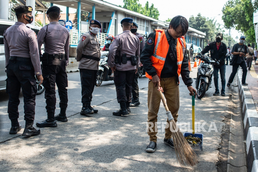 Warga yang melanggar protokol kesehatan menyapu bahu jalan saat terjaring Operasi Yustisi Protokol COVID-19 di kawasan Jati Padang, Jakarta, Kamis (17/9/2020). Polda Metro Jaya dalam operasi gabungan tersebut  hingga Selasa (15/9) mencatat telah memberikan sanksi terhadap 9.734 pelanggar PSBB Jakarta dengan nilai denda sebesar Rp88,6 juta