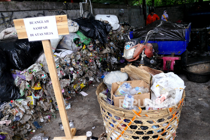 Pekerja memasukkan gerobak sampah ke tempat pemilahan di Kelompok Usaha Pengelolaan Sampah (KUPAS). 