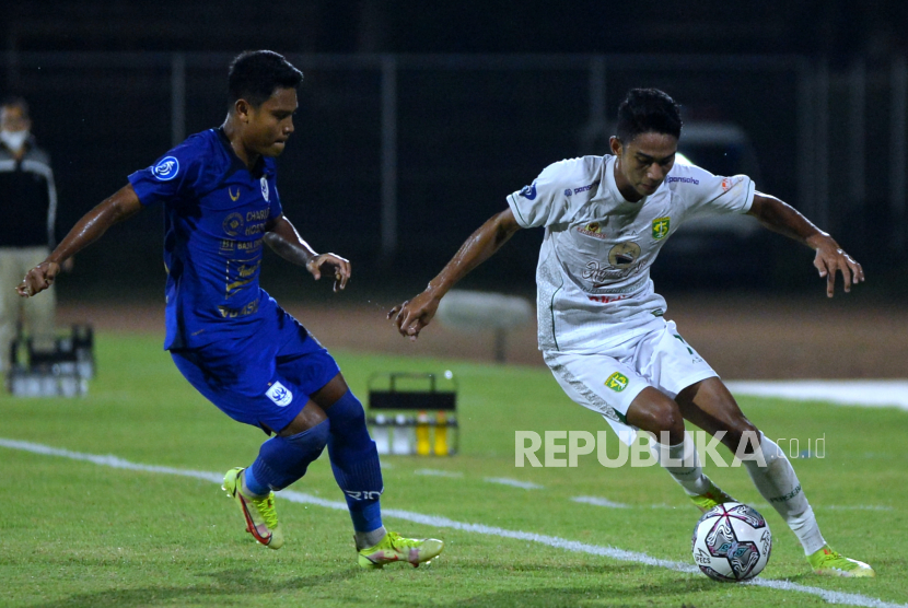Pesepak bola Persebaya Surabaya Marselino Ferdinan (kanan) berebut bola dengan pesepak bola PSIS Semarang Fandi Eko Utomo (kanan) saat pertandingan Liga 1 di Stadion I Gusti Ngurah Rai, Denpasar, Bali, Rabu (2/2/2022). 