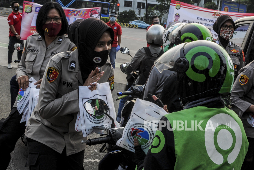 Sejumlah Polisi Wanita memberikan masker 