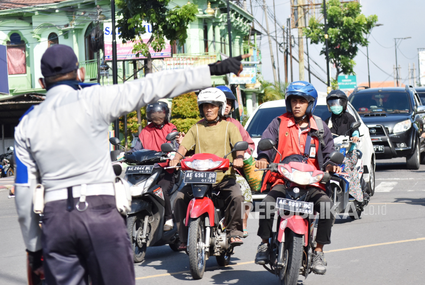 Petugas menertibkan pengendara yang tidak mengenakan masker untuk tidak memasuki kawasan Kota Madiun, Jawa Timur, Rabu (8/4/2020). Pemkot Madiun mulai menerapkan area wajib mengenakan masker bagi warga di ruang publik dan mulai melakukan penertiban bagi pelanggar guna pencegahan penyebaran COVID-19