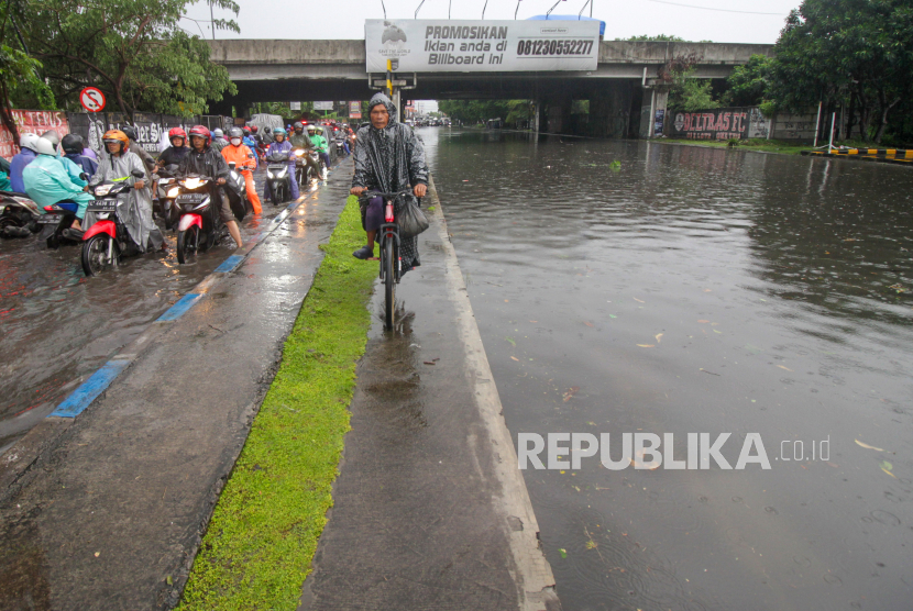 Sejumlah kendaraan berjalan melawan arus saat banjir merendam sebagian Jalan Raya Jati, Sidoarjo, Jawa Timur, Senin (26/2/2024). BRIN ungkap penyebab perpanjangan hujan di Jawa.
