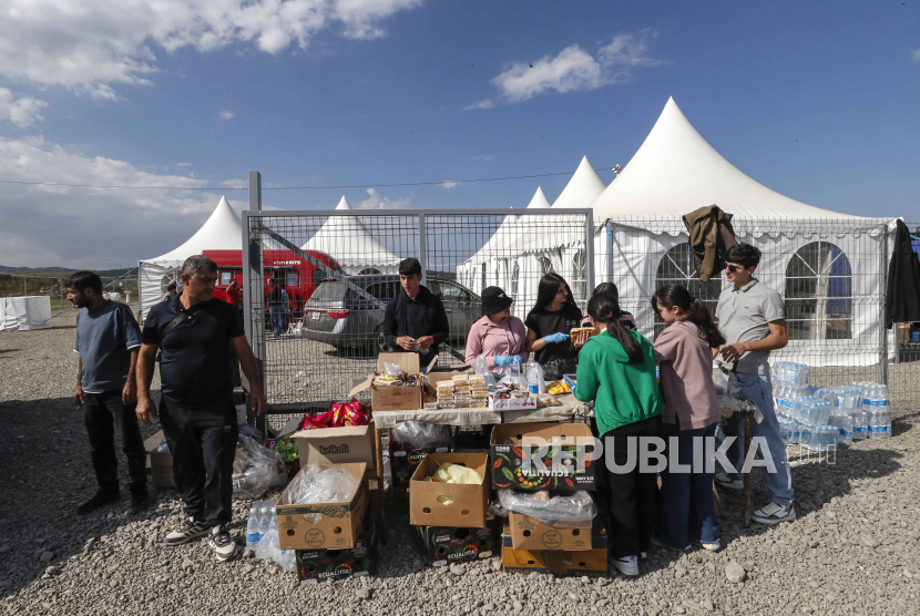 Relawan Armenia mendistribusikan air dan makanan kepada etnis Armenia yang melarikan diri dari wilayah Nagorno-Karabakh dekat desa Kornidzor, Armenia, 28 September 2023.