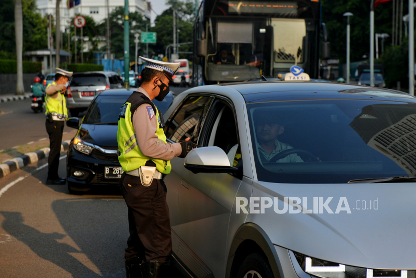 Petugas Kepolisian melakukan penindakan tilang manual terhadap pengemudi di kawasan Bundaran Hotel Indonesia, Jakarta, Selasa (16/5/2023). Polri kembali memberlakukan tilang manual terhadap pengemudi yang melanggar lalu lintas. Kebijakan tersebut kembali diberlakukan lantaran pelanggaran lalu lintas meningkat di wilayah yang tidak terjangkau ETLE. Meski demikian, tilang elektroni akan tetap dioperasionalkan.
