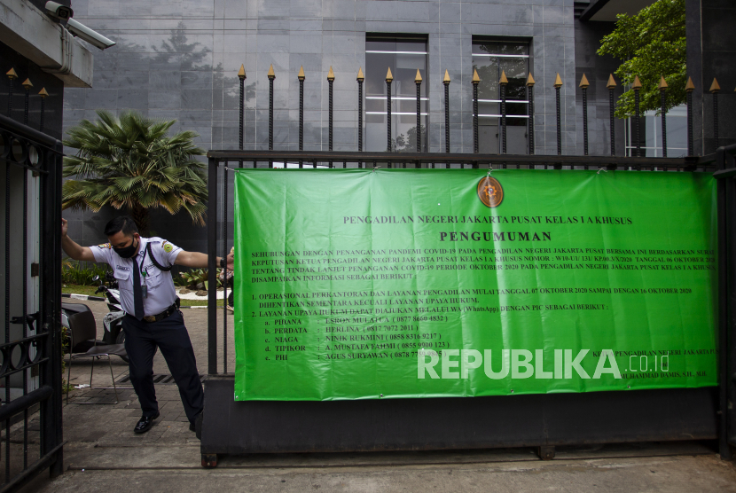 Petugas keamanan menutup pagar gedung Pengadilan Negeri Jakarta Pusat di Kemayoran, Jakarta, Rabu (7/10/2020). 