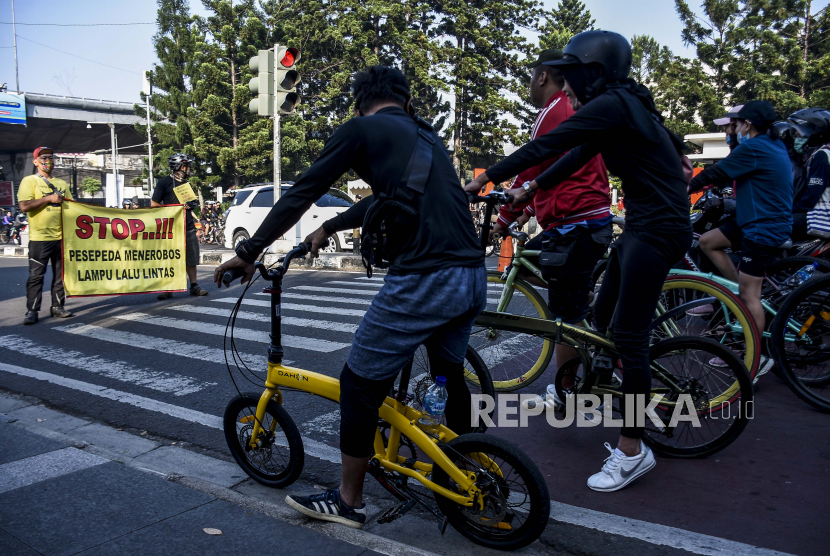 Anggota dari Forum Komunikasi Pesepeda Bandung Raya membentangkan spanduk imbauan saat Kampanye Tertib Bersepeda di Jalan Ir H Djuanda, Kota Bandung, Ahad (19/7). 