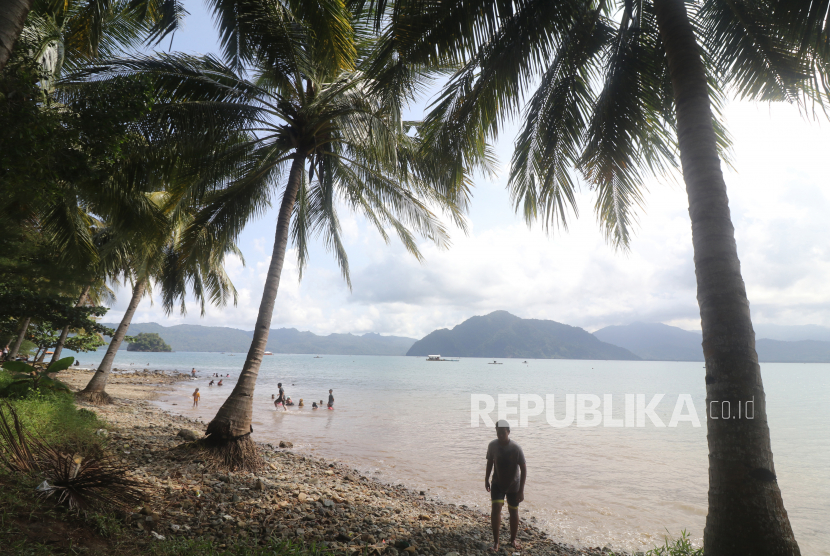 Pengunjung bermain air di pantai Trenggalek, Jawa Timur. Empat wisawatan remaja terseret ombak di Pantai Prigi, Trenggalek, satu masih dicari.