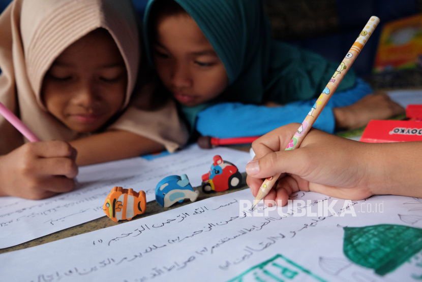 Sejumlah anak belajar menyalin surat Al Fatihah pada Kitab Al Quran didampingi orang tua di rumahnya di Solo, Jawa Tengah. Terkait literasi, menulis dengan tangan di atas kertas bisa jadi terlihat kuno pada era digital seperti saat ini. Tapi, ternyata fakta menunjukkan belajar menulis dengan tangan sejak usia dini masih sangat penting untuk anak-anak.