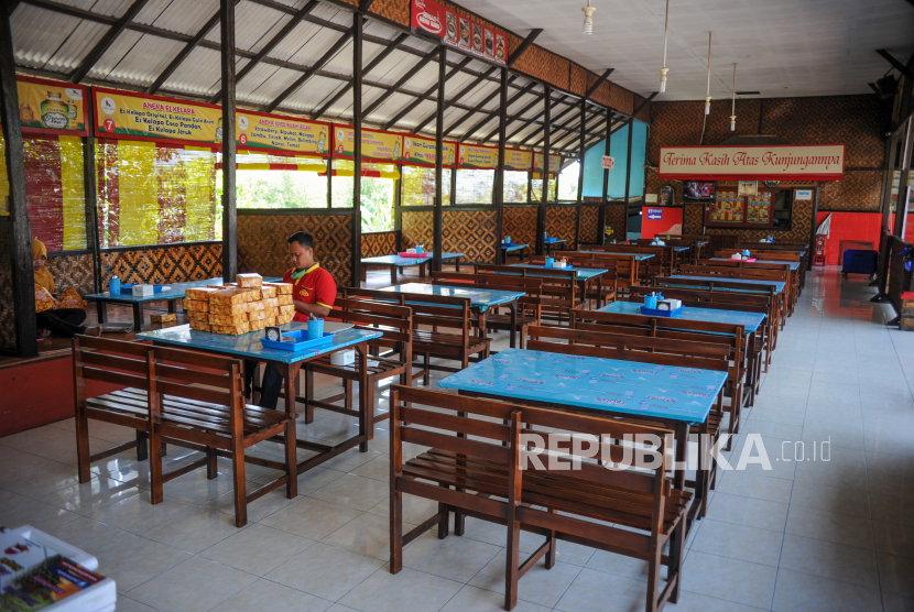 Seorang pekerja berada di sebuah rumah makan yang sepi di Nagreg, Kabupaten Bandung, Jawa Barat,  Ahad (9/5/2021). Sejak adanya larangan mudik lebaran yang ditetapkan pada 6 Mei 2021 lalu, pengusaha menyatakan penghasilan mereka di H-5 Idul Fitri 1442 H menurun hingga 90 persen bahkan sebagian pengusaha memilih untuk menutup tokonya. 