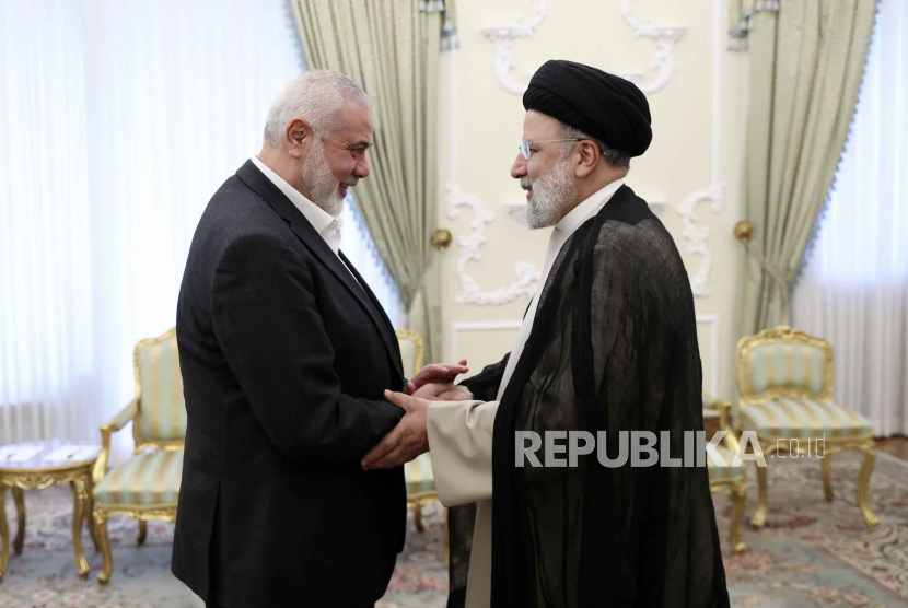 In this photo released by the Iranian Presidency Office, Iranian President Ebrahim Raisi, right, shakes hands with Hamas chief Ismail Haniyeh at his office in Tehran, Iran, Wednesday, March 27, 2024.  