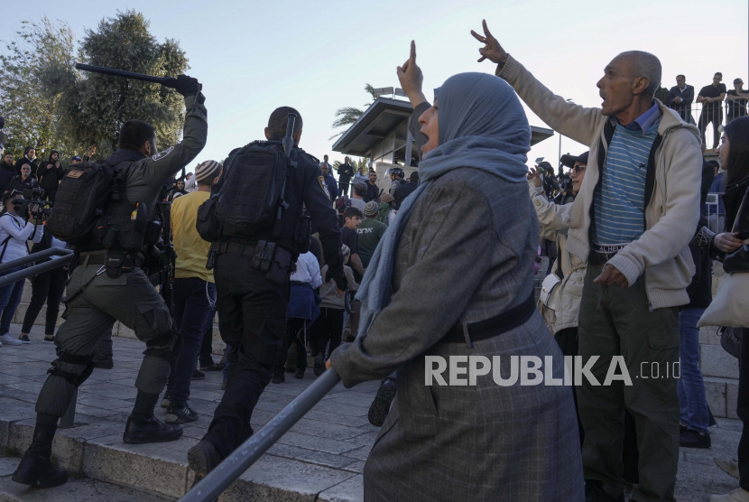 Warga Palestina meneriakkan slogan-slogan saat pasukan keamanan Israel mengawal sekelompok orang Yahudi di luar Gerbang Damaskus, di Kota Tua Yerusalem, Rabu, 20 April 2022. 