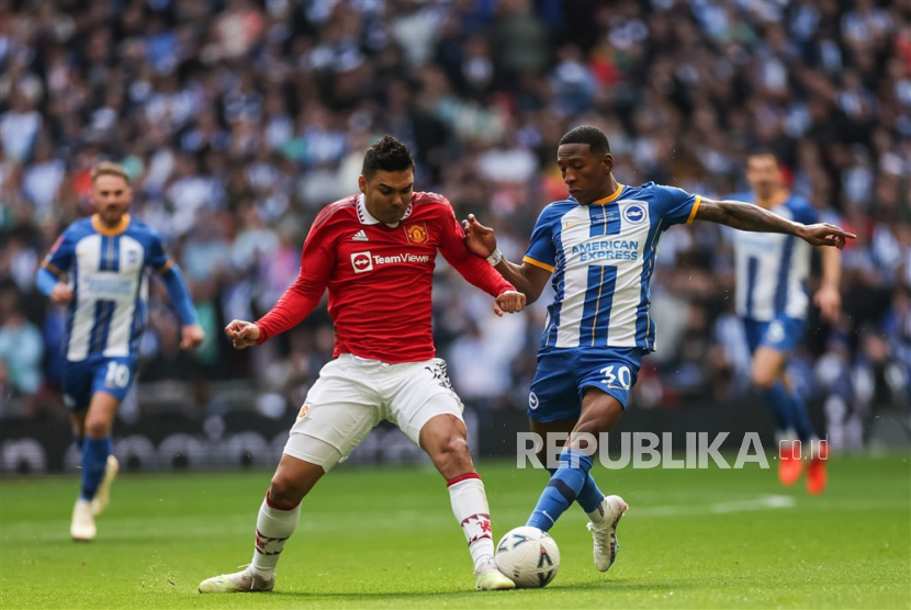 Gelandang Manchester United, Casemiro (kiri), berebut bola dengan pemain Brighton & Hove Albion, Pervis Estupinan, pada laga semifinal Piala FA di Stadion Wembley, London, Inggris, pada Ahad (23/4/2023).  