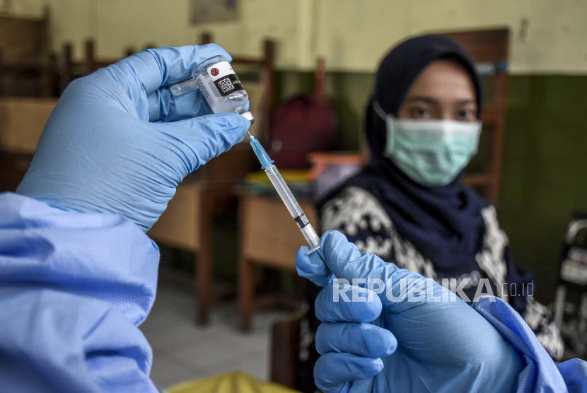 Vaksinator bersiap menyuntikan vaksin Covid-19 ke guru di SDN 023 Pajagalan, Kota Bandung, Rabu (14/4). Dinas Kesehatan Kota Bandung terus menggencarkan vaksinasi Covid-19 terhadap guru dan tenaga pendidik jelang pembelajaran tatap muka pada Juli mendatang. Hingga saat ini, sudah terdapat 2.744 guru dan tenaga pendidik yang telah menerima vaksin Covid-19 dosis pertama. Foto: Republika/Abdan Syakura