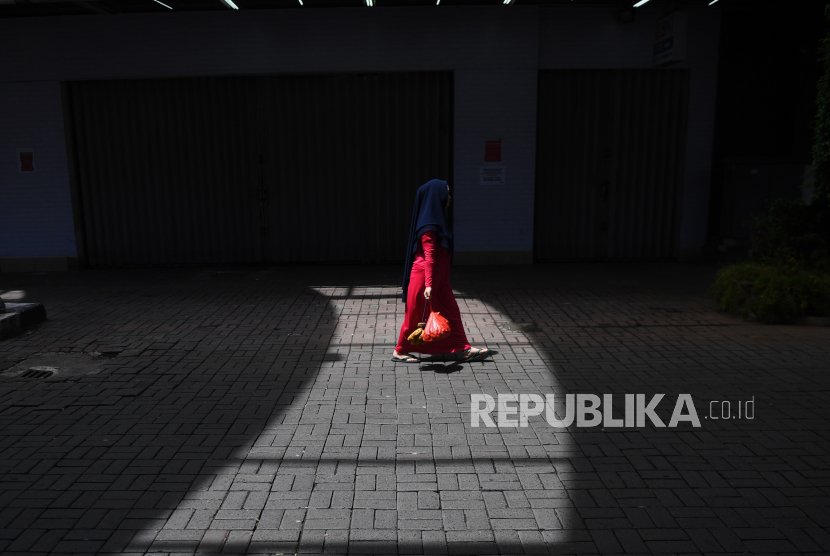 Seorang wanita melintasi deretan toko yang tutup di Pasar Baru, Jakarta, Rabu (1/4/2020). Menteri Keuangan Sri Mulyani menyatakan pertumbuhan ekonomi Indonesia tahun 2020 akan turun menjadi 2,3 persen dan dalam skenario terburuk bahkan bisa mencapai -0,4 persen akibat dampak dari pandemi COVID-19