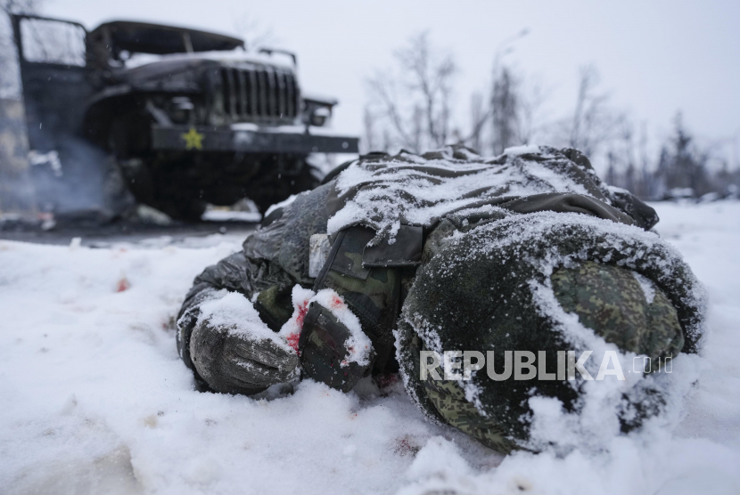 Mayat seorang prajurit yang dilapisi salju di sebelah kendaraan peluncur roket ganda militer Rusia yang hancur di pinggiran Kharkiv, Ukraina, Jumat, 25 Februari 2022. Organisasi Kesehatan Dunia (WHO) memperingatkan kehidupan jutaan orang akan terancam di Ukraina pada musim dingin ini. 