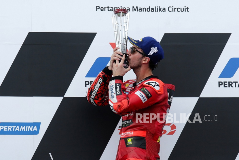Murid Valentino Rossi, Francesco Bagnaia melakukan selebrasi dengan trofi di podium usai menjuarai Grand Prix Indonesia di Sirkuit Internasional Pertamina Mandalik, Ahad (15/10/2023).