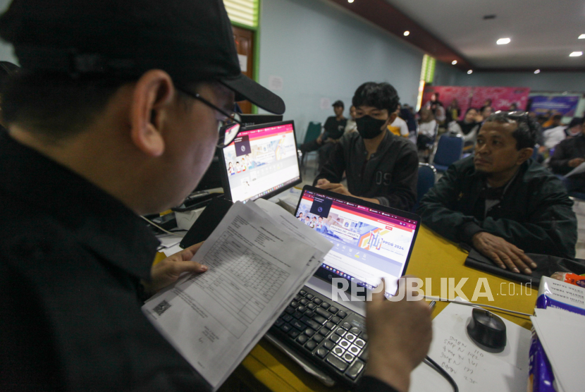 Petugas melayani orang tua calon peserta didik membuat akun PPDB di posko pelayanan PPDB di SMAN 70 Bulungan, Kebayoran Baru, Jakarta Selatan, Selasa (4/6/2024).