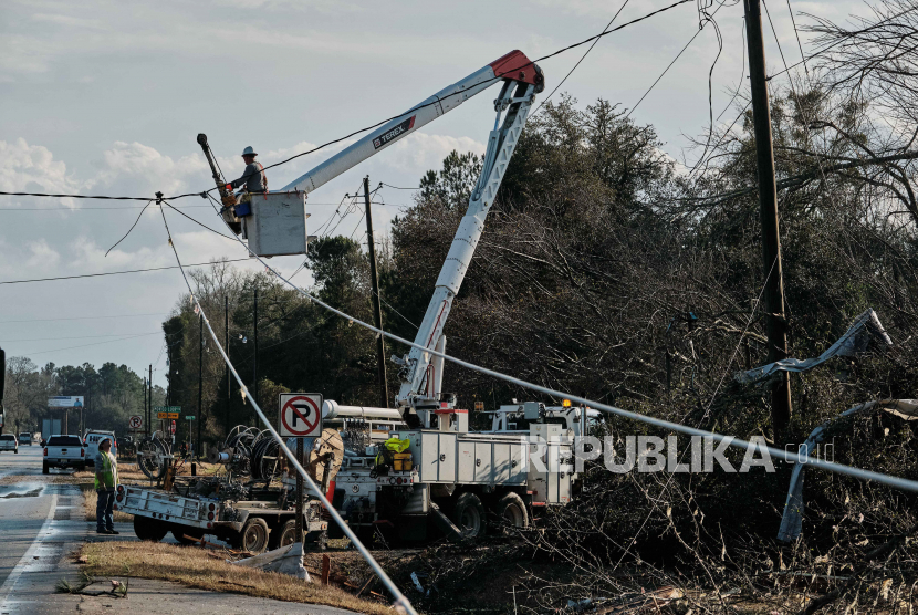 Kru darurat bekerja pada kabel listrik yang tumbang setelah tornado mendarat di Mount Vernon, Alabama AS pada 12 Januari 2023.