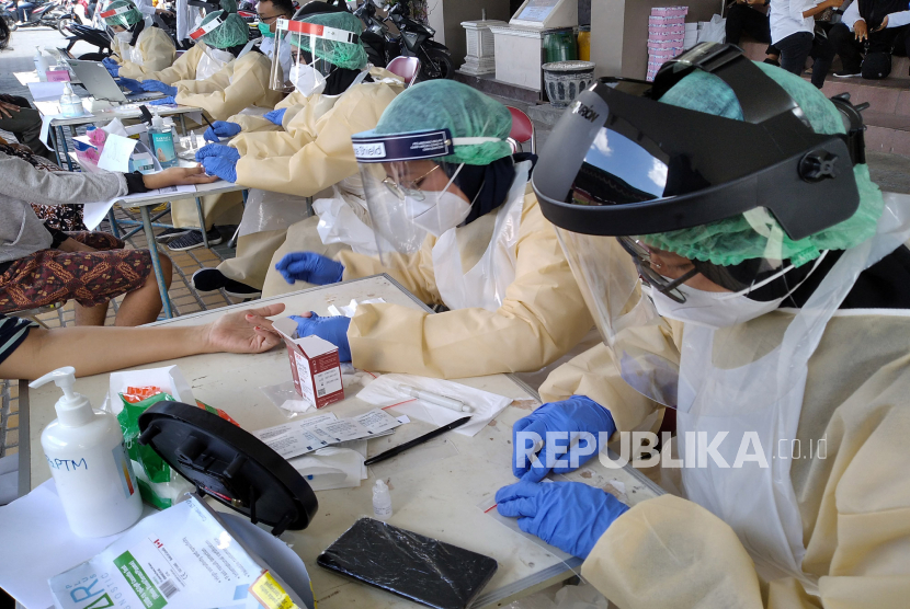 Tenaga medis mengambil sampel darah pedagang saat Rapid Diagnostic Test (RDT) Covid-19 di Pasar Bantul, Yogyakarta, Rabu (24/6). Dinas Kesehatan Bantul  menyebut total ada karyawan dan pedagang sebanyak 700 orang pedagang Pasar Bantul yang akan menjalani rapid test pada Rabu (24/6) dan Kamis (25/6). Pasar Bantul diprioritaskan untuk digelar rapid test, karena memiliki potensi penularan Covid-19 karena banyak didatangi pedagang dari luar daerah.