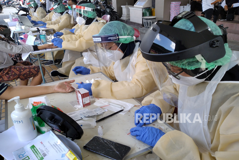 Tenaga medis mengambil sampel darah pedagang saat Rapid Diagnostic Test (RDT) Covid-19 di Pasar Bantul, Yogyakarta, Rabu (24/6). Dinas Kesehatan Bantul  menyebut total ada karyawan dan pedagang sebanyak 700 orang pedagang Pasar Bantul yang akan menjalani rapid test. Pada Selasa (30/6), DIY catatan tambahan kasus positif Covid-19, lima di antaranya adalah sekeluarga dari Bantul.