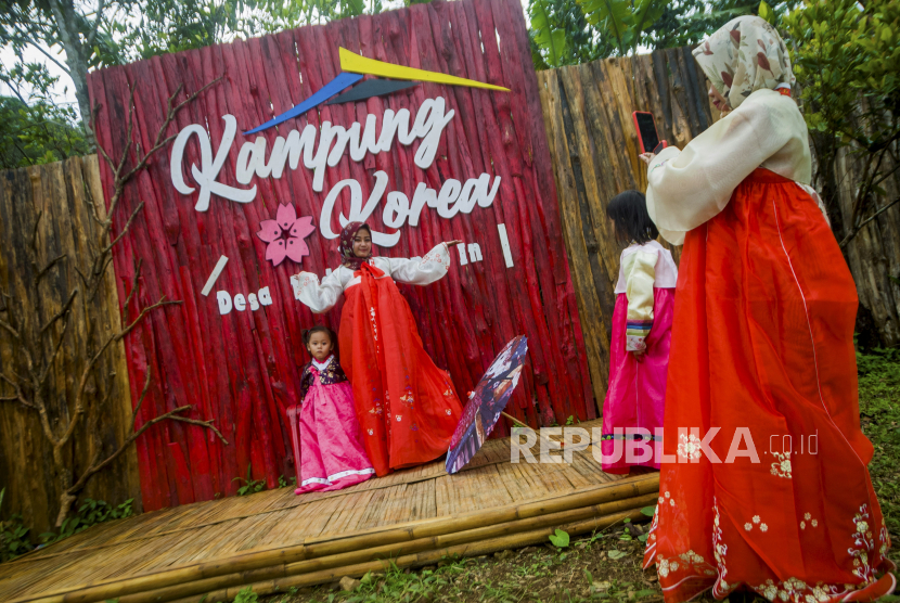 Wisatawan menggunakan pakaian tradisional Korea (Hanbok) berswafoto di Wisata Kampung Korea.