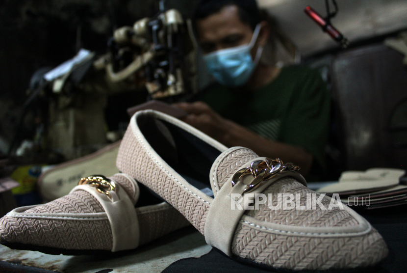 Pekerja memproduksi sepatu wanita yang dipasarkan melalui lokapasar di Ciomas, Kabupaten Bogor, Jawa Barat, Sabtu (6/3/2021).
