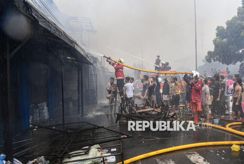 Petugas pemadam kebakaran bersama warga berusaha memadamkan api yang membakar permukiman padat penduduk di kawasan Kebon Kosong, Kemayoran, Jakarta, Selasa (10/12/2024).