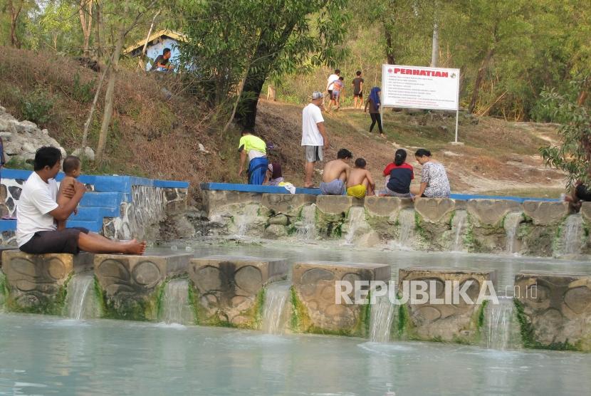 Sejumlah pengunjung sedang menikmati aliran air panas di objek wisata Banyu Panas di desa Palimanan Barat Kecamatan Gempol Cirebon, Jawa Barat, Ahad (17/6).