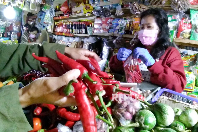 Pengunjung pasar memilih cabai merah di pasar tradisional. ilustrasi