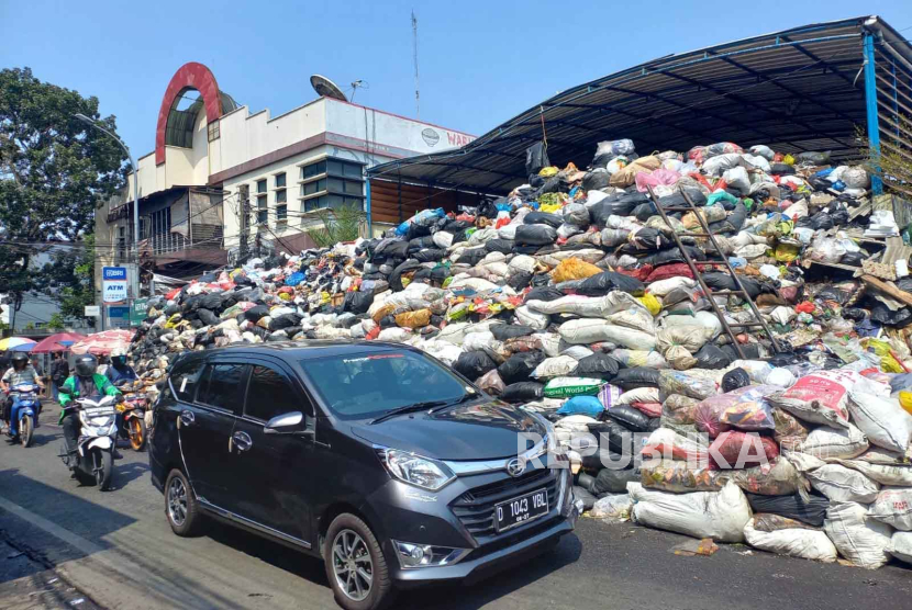 Tumpukan sampah menggunung di TPS Sederhana, Kota Bandung mengakibatkan sebagian badan jalan terambil, bau menyengat dan bermunculan belatung di area jalan, Rabu (20/9/2023). 