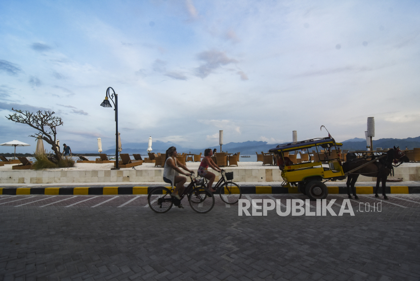 Wisatawan asing menaiki sepeda di pinggiran pantai wisata Gili Trawangan, Kecamatan Pemenang, Tanjung, Lombok Utara, NTB, Rabu (14/12/2022). Badan Pusat Statistik (BPS) mencatat jumlah wisatawan mancanegara (wisman) sepanjang 2022 melampaui target pemerintah. 