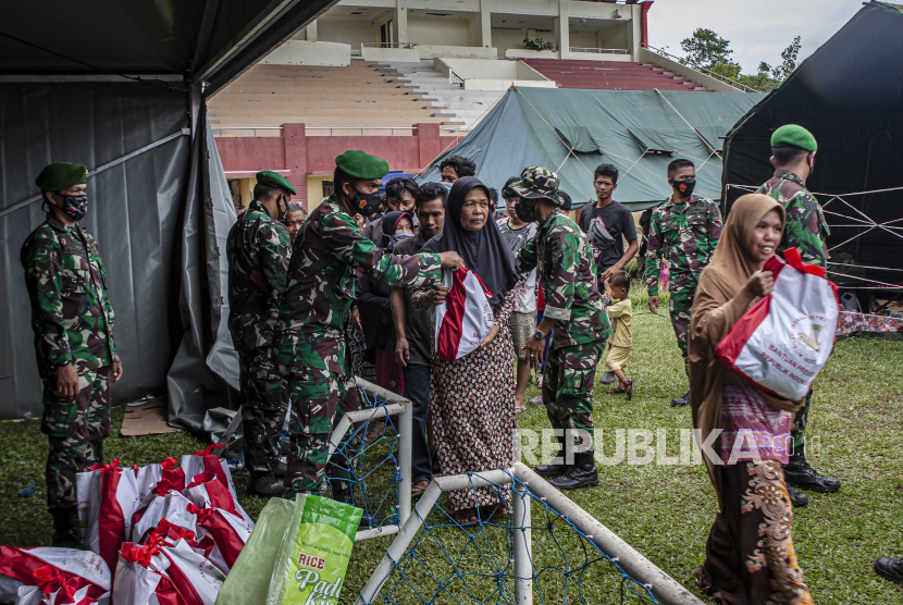  Tentara mendistribusikan barang bantuan kepada orang-orang yang mengungsi akibat gempa bumi baru-baru ini di tempat penampungan sementara di Mamuju, Sulawesi Barat, Indonesia, Selasa (19/1).
