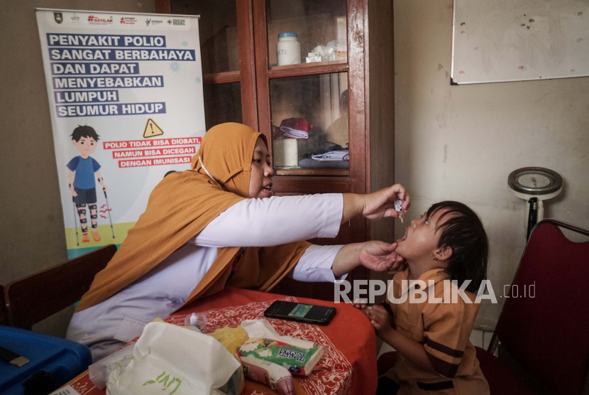 Petugas puskesmas memberikan vaksin polio kepada anak.