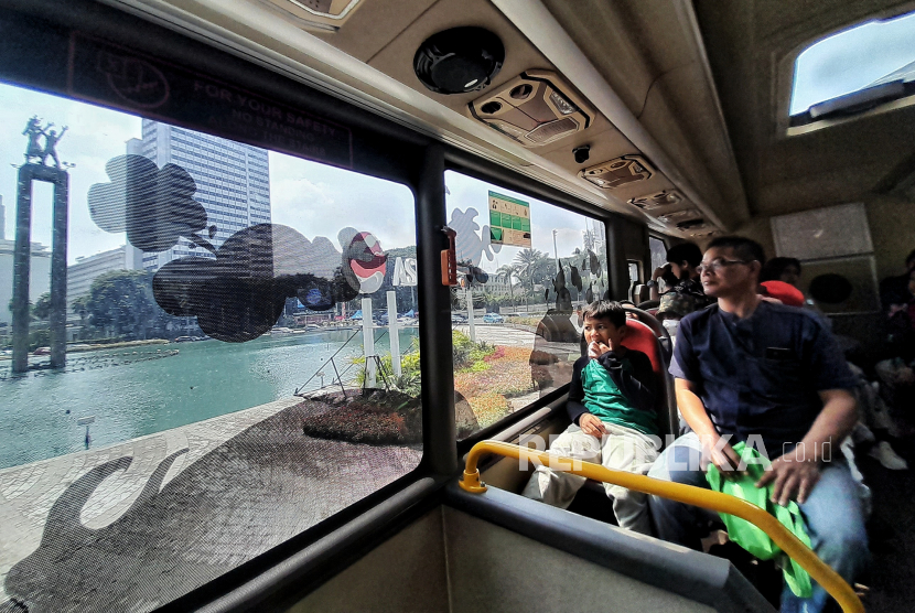 Warga menaiki bus tingkat mengelilingi kawasan Monumen Nasional-Bundaran Hotel Indonesia, Jakarta, Rabu (28/6/2023). Jakarta masuk di daftar Best Cities to Visit in 2024 versi Lonely Planet. 