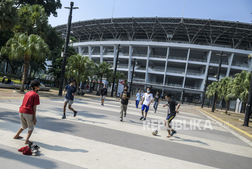 Warga bermain sepak bola di kawasan Stadion Utama Gelora Bung Karno (SUGBK) di Senayan, Jakarta, Minggu (13/9/2020). Jelang penerapan Pembatasan Sosial Berskala Besar (PSBB) total yang rencananya dilaksanakan pada Senin (14/9/2020) masih banyak masyarakat yang melakukan olahraga dan beraktivitas di luar rumah. 