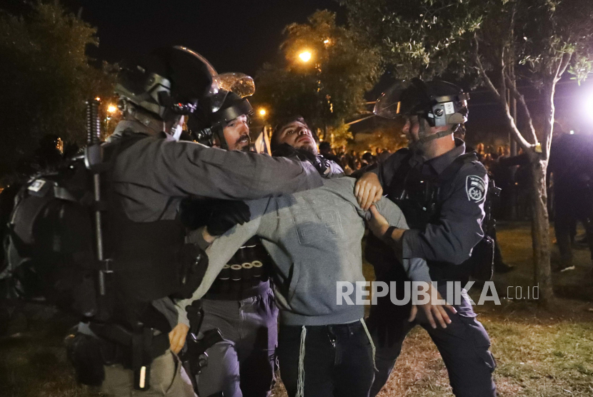 Polisi perbatasan Israel menahan seorang pemuda Israel sebagai anggota Lahava, sebuah kelompok ekstremis Yahudi, ketika mereka mencoba mendekati Gerbang Damaskus untuk memprotes di tengah ketegangan yang meningkat di kota itu, tepat di luar Kota Tua Yerusalem, Kamis, April. 22, 2021.