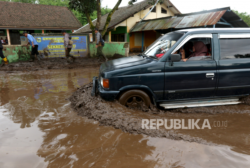 Warga menggunakan mobil menerjang lumpur yang menggenangi jalan di Desa Sempol, Ijen, Bondowoso, Jawa Timur, Senin (13/2/2023). Terjadi banjir bandang susulan pada sore hari yang menyebabkan terganggunya jalur lalu lintas penghubung Bondowoso-Banyuwangi karena terendam material lumpur. ANTARA FOTO/Budi Candra Setya/rwa.