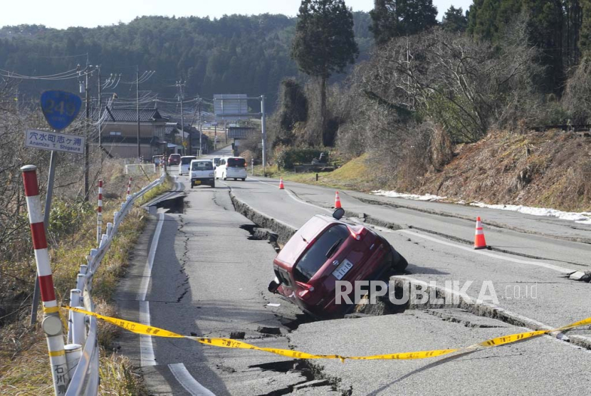 Sebuah mobil terjebak di jalan yang sebagian runtuh akibat gempa bumi dahsyat di dekat Kota Anamizu, Prefektur Ishikawa, Jepang.