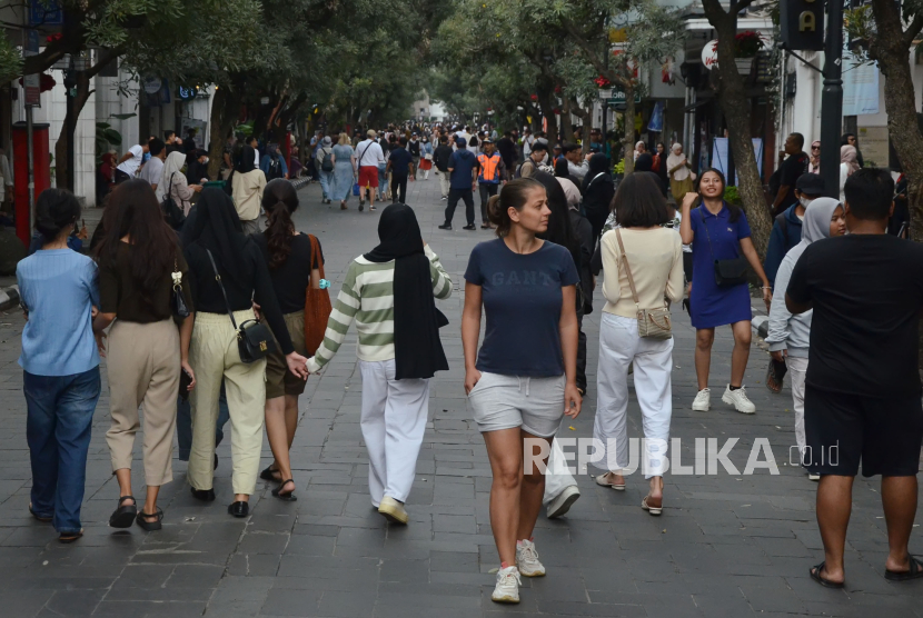Pengunjung termasuk wisatawan mancanegara berjalan-jalan menikmati Braga Free Vehicle atau Braga tanpa kendaraan, di Jalan Braga, Kota Bandung. Jumlah wisman ke Indonesia mengalami kenaikan. 