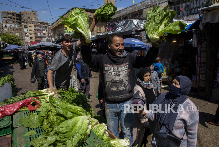 Pedagang berteriak untuk mengumumkan diskon untuk selada dan sayuran lainnya untuk persiapan Ramadhan di sebuah pasar di Beirut, Lebanon, Senin, 12 April 2021.