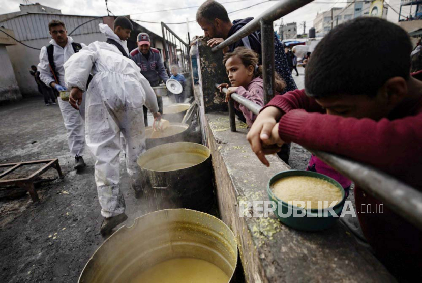 Pengungsi Palestina memegang mangkuk kosong saat berbaris untuk menerima bantuan makanan yang diberikan oleh kelompok pemuda Palestina di kamp pengungsi Rafah, Jalur Gaza selatan, (7/3/2024).