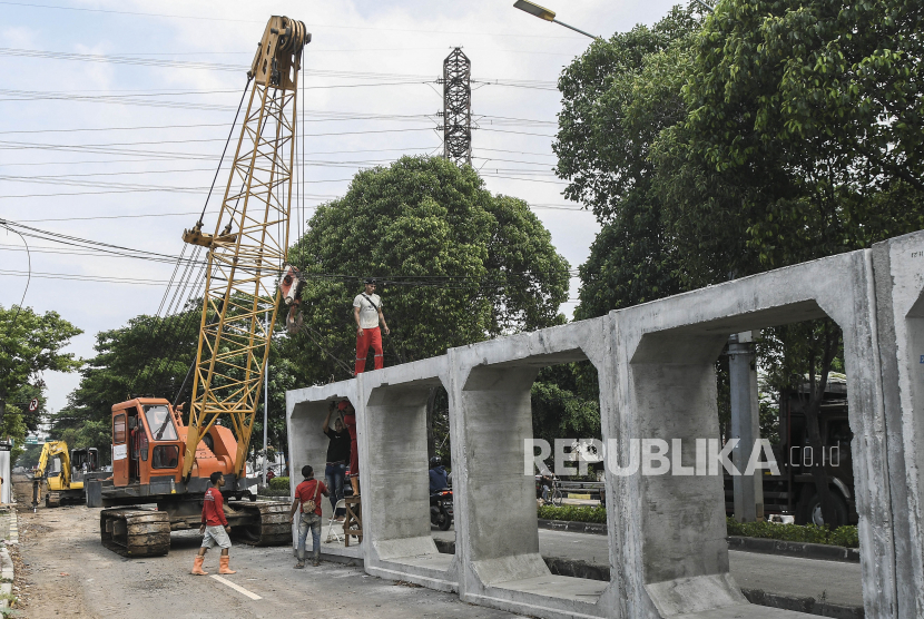 Sejumlah pekerja menggunakan alat berat memindahkan box culvert untuk proyek pembangunan saluran drainase di Jalan I Gusti Ngurah Rai, Duren Sawit, Jakarta Timur, Rabu (8/12/2021). Pembangunan saluran sepanjang 800 meter itu akan difungsikan sebagai drainase untuk mengatasi terjadinya genangan air di sekitar wilayah tersebut dan ditargetkan selesai pada akhir Desember 2021. 