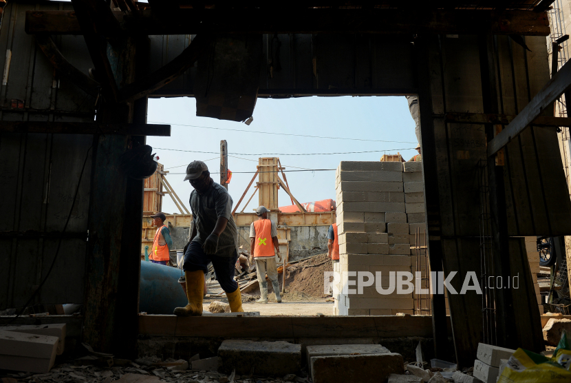 Pekerja menyelesaikan proyek peninggian tanggul di kawasan Muara Baru, Jakarta Utara, Jumat (6/10/2023). 
