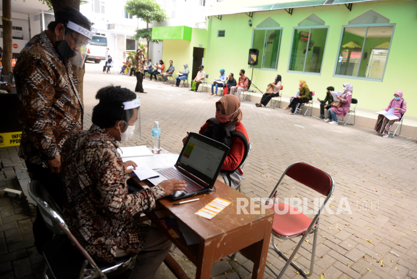 Petugas menggunakan pelindung wajah dan masker melayani konsultasi pendaftaran PPDB di posko PPDB SMP Dinas Pendidikan Kota Yogyakarta, Kamis (4/6). Orangtua wali mendatangi posko PPDB untuk pengajuan dan aktivasi akun akun PPDB Online