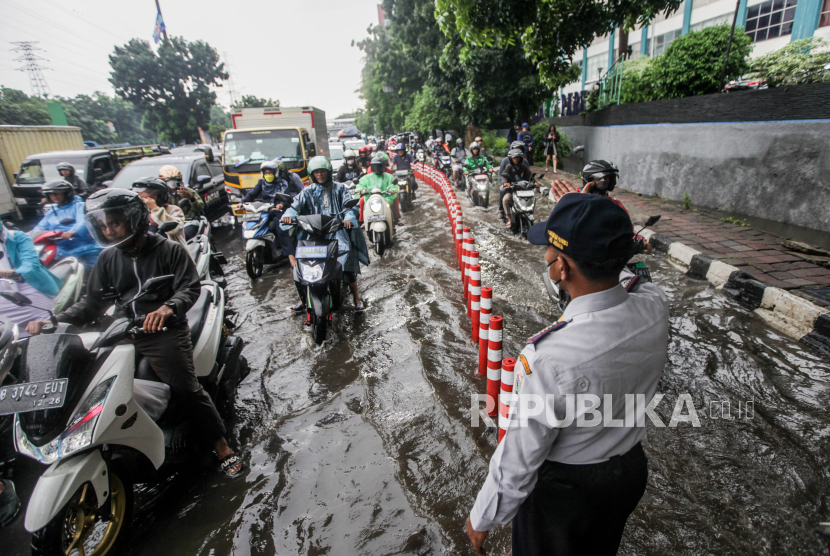 Pengendara motor melewati genangan air di Jalan DI Pandjaitan, Jatinegara, Jakarta Timur, Senin (5/2/2024). Sebagian besar daerah di Indonesia berpotensi diterpa hujan lebat yang disertai dengan petir