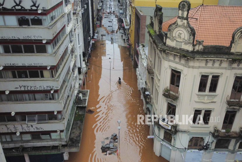 Seorang pengendara sepeda melintasi jalan yang dibanjiri hujan lebat di Porto Alegre, negara bagian Rio Grande do Sul, Brasil, Sabtu, 4 Mei 2024.
