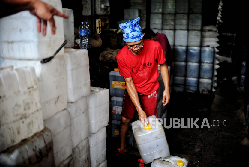 Pekerja mengangkat jeriken berisi minyak di agen minyak curah di kawasan Kebayoran Lama, Jakarta Selatan, Kamis (26/5/2022). Jakarta mengalami inflasi pada Mei 2022, salah satunya karena harga minyak goreng.