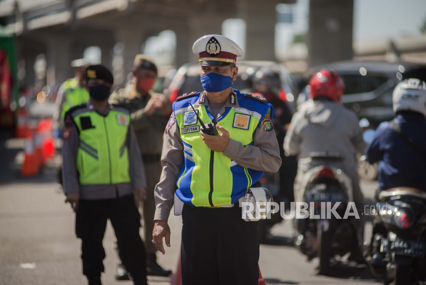 Petugas kepolisian mengatur lalu lintas pada Hari Raya Idul Fitri 1441 Hijriyah di jalur perbatasan Jakarta-Bekasi, Bekasi, Jawa Barat, Ahad (24/5). Pada Hari Raya Idul Fitri 1441 Hiriyah salah satu jalur arus mudik terpantau ramai lancar