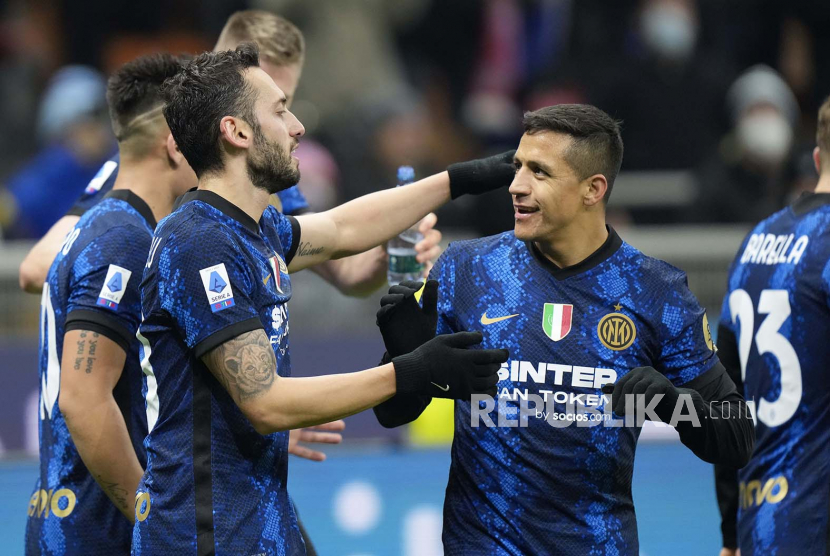 Pemain Inter Milan Alexis Sanchez, kanan, memberi selamat kepada rekan setimnya Hakan Calhanoglu yang mencetak gol ketiga timnya selama pertandingan sepak bola Serie A antara Inter Milan dan Cagliari di stadion San Siro di Milan, Italia,Senin (13/12) dini hari WIB.