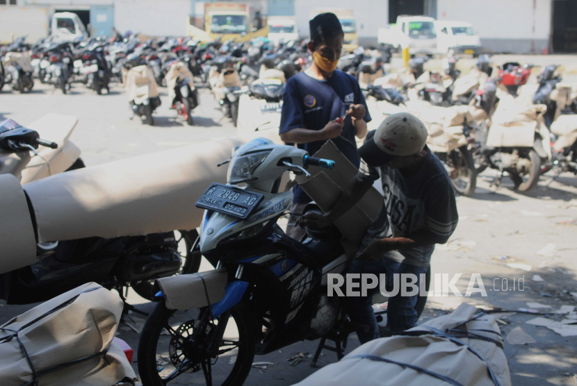 Petugas saat mengemas sepeda motor yang akan dikirim ke daerah asal pemudik di Stasiun Jakarta Gudang KAI Logistik, Kampung Bandan, Jakarta, Jumat (14/4/2023). Pemudik motor melalui Pelabuhan Ciwandan diminta untuk mengatur keberangkatan.